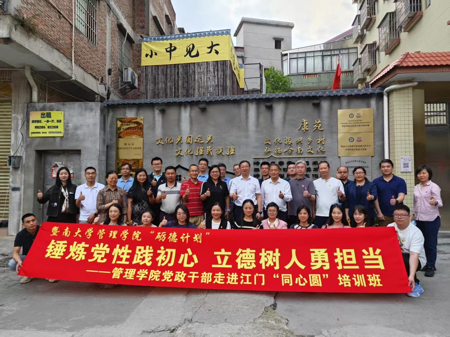 参访团队在入口文化墙前手持红色横幅合影