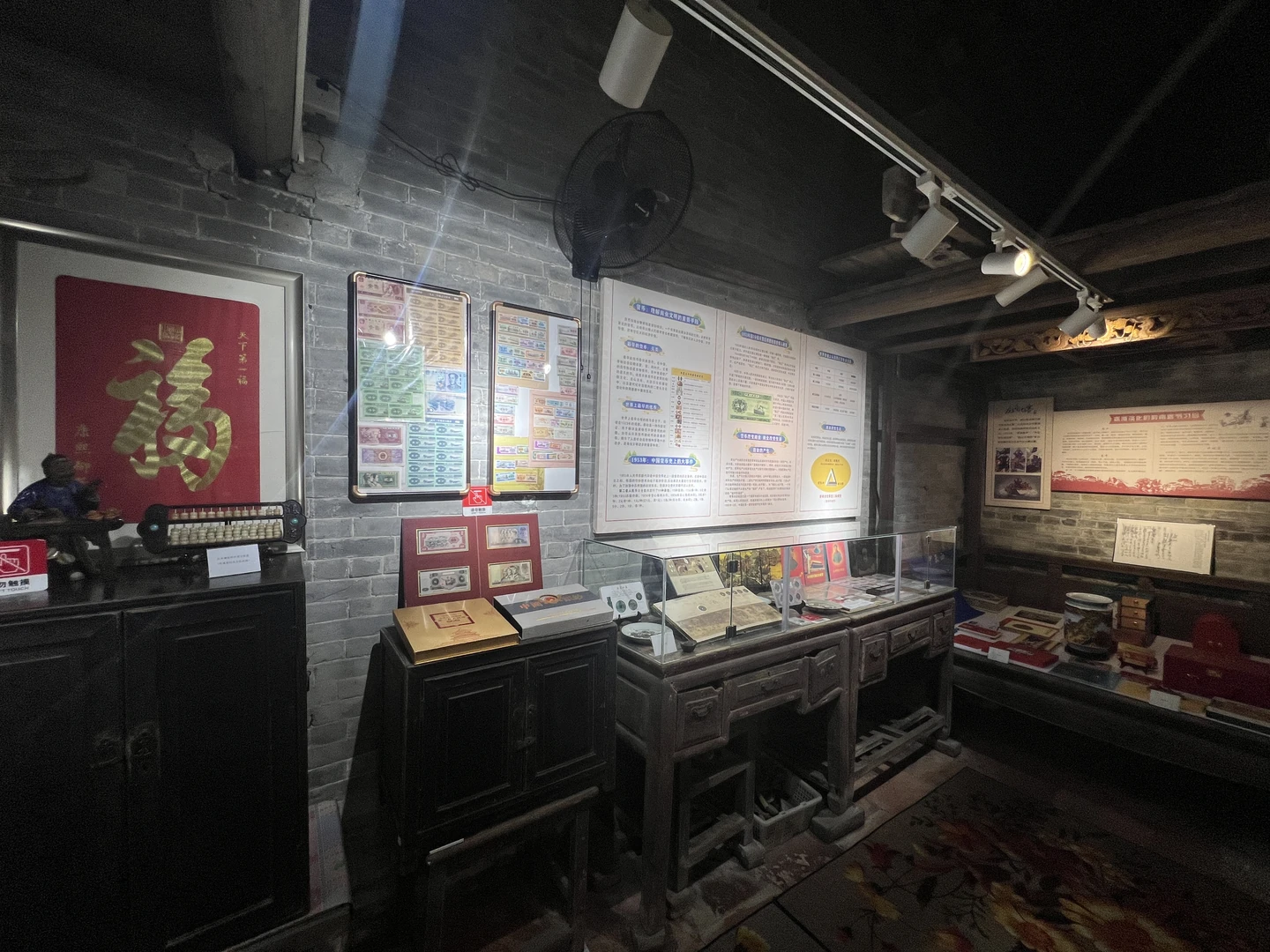 青砖展室中的纸币陈列、算盘、玻璃展柜与说明牌